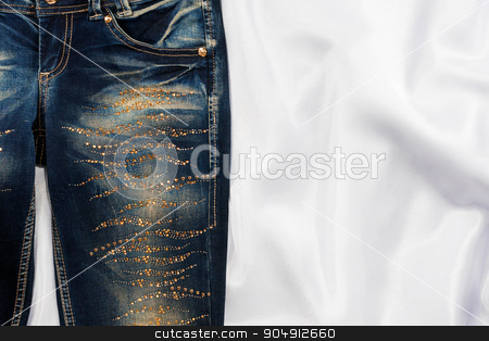 To use this stock image in your creative project, please select the size you need over to the right and click the "Add to Cart" button.
Your downloaded image will come with the Cutcaster watermark removed so don’t worry about the watermark you see on this page. Trendy jeans with rhinestones lies on white silk stock photo, Trendy jeans with rhinestones lies on white silk, with space for your text by alekleks