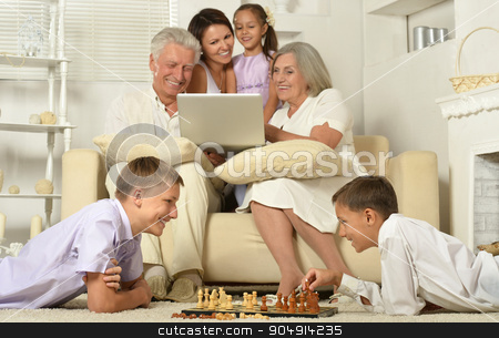 To use this stock image in your creative project, please select the size you need over to the right and click the "Add to Cart" button.
Your downloaded image will come with the Cutcaster watermark removed so don’t worry about the watermark you see on this page. Happy family with kids with laptop stock photo, Happy family with kids on couch in living room with laptop,boys playing chess by Ruslan Huzau