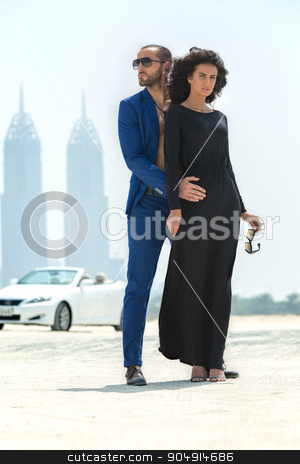 To use this stock image in your creative project, please select the size you need over to the right and click the "Add to Cart" button.
Your downloaded image will come with the Cutcaster watermark removed so don’t worry about the watermark you see on this page. Couple on the background of skyscrapers stock photo, Young couple arrived in a white car to walk on a deserted beach in Dubai on the background of skyscrapers. The dark-haired girl in black dress took off her glasses and looking at the camera. The dark by bezikus