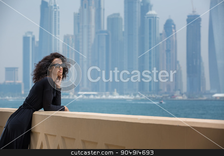 To use this stock image in your creative project, please select the size you need over to the right and click the "Add to Cart" button.
Your downloaded image will come with the Cutcaster watermark removed so don’t worry about the watermark you see on this page. Woman on the background of skyscrapers stock photo, Refined dark-haired girl in black dress on the background of skyscrapers in Dubai. Admiring the sea. UAE. Horizontal photo by bezikus