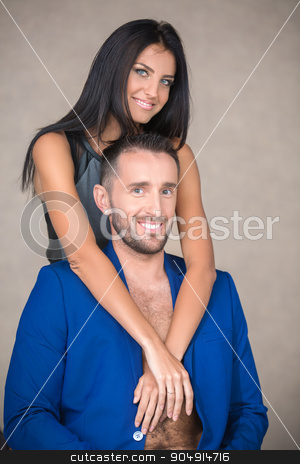 To use this stock image in your creative project, please select the size you need over to the right and click the "Add to Cart" button.
Your downloaded image will come with the Cutcaster watermark removed so don’t worry about the watermark you see on this page. Young couple in the studio stock photo, Attractive couple in embrace on a brown background. The slender blue-eyed girl with long dark hair in a gray-black dress hugs the neck man in a blue suit with a beard. Vertical photo by bezikus
