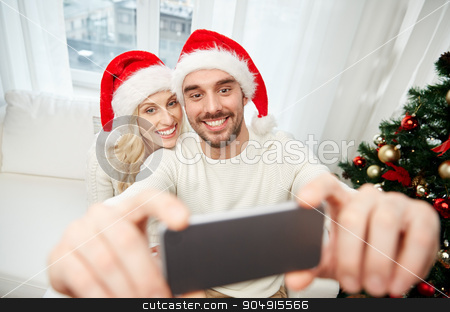 To use this stock image in your creative project, please select the size you need over to the right and click the "Add to Cart" button.
Your downloaded image will come with the Cutcaster watermark removed so don’t worry about the watermark you see on this page. couple taking selfie with smartphone at christmas stock photo, christmas, holidays, technology and people concept - happy couple in santa hats taking selfie picture with smartphone at home by Syda Productions