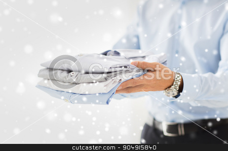 To use this stock image in your creative project, please select the size you need over to the right and click the "Add to Cart" button.
Your downloaded image will come with the Cutcaster watermark removed so don’t worry about the watermark you see on this page. close up of businessman holding folded shirts stock photo, business, clothing and people concept - close up of businessman holding folded shirts over snow effect by Syda Productions