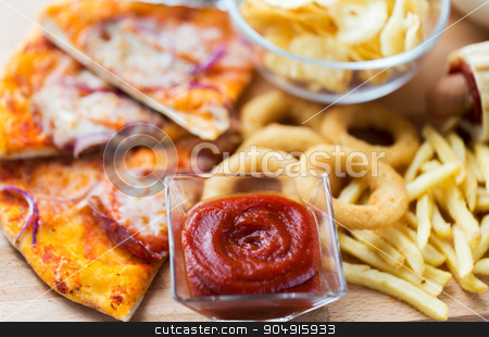 To use this stock image in your creative project, please select the size you need over to the right and click the "Add to Cart" button.
Your downloaded image will come with the Cutcaster watermark removed so don’t worry about the watermark you see on this page. close up of fast food snacks on wooden table stock photo, fast food and unhealthy eating concept - close up of ketchup in glass bowl over pizza, deep-fried squid rings, potato chips, peanuts and ketchup on wooden table by Syda Productions