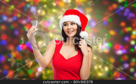 To use this stock image in your creative project, please select the size you need over to the right and click the "Add to Cart" button.
Your downloaded image will come with the Cutcaster watermark removed so don’t worry about the watermark you see on this page. woman in santa hat taking selfie by smartphone stock photo, people, holidays, christmas and technology concept - beautiful sexy woman in red santa hat taking selfie picture by smartphone over party lights background by Syda Productions
