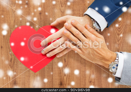 To use this stock image in your creative project, please select the size you need over to the right and click the "Add to Cart" button.
Your downloaded image will come with the Cutcaster watermark removed so don’t worry about the watermark you see on this page. close up of male gay couple hands with red heart stock photo, people, homosexuality, same-sex marriage, valentines day and love concept - close up of happy married male gay couple hands with red paper heart shape over wooden background and snow effect by Syda Productions