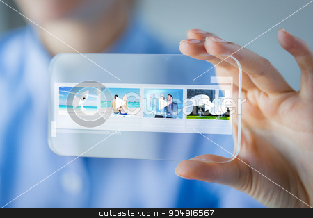 To use this stock image in your creative project, please select the size you need over to the right and click the "Add to Cart" button.
Your downloaded image will come with the Cutcaster watermark removed so don’t worry about the watermark you see on this page. close up of woman with transparent smartphone stock photo, business, technology and people concept - close up of woman hand holding and showing transparent smartphone with media player icons on screen at office by Syda Productions