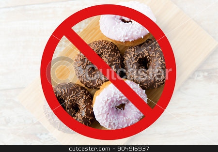 To use this stock image in your creative project, please select the size you need over to the right and click the "Add to Cart" button.
Your downloaded image will come with the Cutcaster watermark removed so don’t worry about the watermark you see on this page. close up of glazed donuts pile behind no symbol stock photo, fast food, low carb diet, fattening and unhealthy eating concept - close up of glazed donuts on wooden board behind no symbol or circle-backslash prohibition sign by Syda Productions