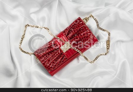 To use this stock image in your creative project, please select the size you need over to the right and click the "Add to Cart" button.
Your downloaded image will come with the Cutcaster watermark removed so don’t worry about the watermark you see on this page. Red lacquer bag lying on a white silk stock photo, Red lacquer bag lying on a white silk, as background by alekleks