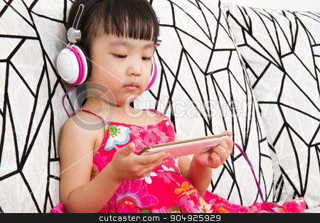 To use this stock image in your creative project, please select the size you need over to the right and click the "Add to Cart" button.
Your downloaded image will come with the Cutcaster watermark removed so don’t worry about the watermark you see on this page. Chinese little girl on headphones holding mobile phone stock photo, Chinese little girl on headphones holding mobile phone sitting on sofa by Tan Kian Khoon