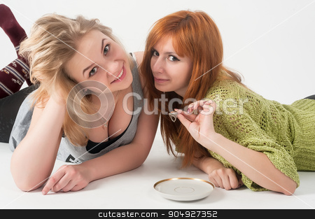 To use this stock image in your creative project, please select the size you need over to the right and click the "Add to Cart" button.
Your downloaded image will come with the Cutcaster watermark removed so don’t worry about the watermark you see on this page. Two attractive girls lie and have fun stock photo, Beautiful girlfriends on floor guessing by means of a wedding ring over white background by Aikon