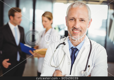 To use this stock image in your creative project, please select the size you need over to the right and click the "Add to Cart" button.
Your downloaded image will come with the Cutcaster watermark removed so don’t worry about the watermark you see on this page. Portrait of a smiling male doctor in hospital stock photo, Portrait of a smiling male doctor standing in the hospital by Wavebreak Media