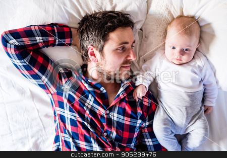 To use this stock image in your creative project, please select the size you need over to the right and click the "Add to Cart" button.
Your downloaded image will come with the Cutcaster watermark removed so don’t worry about the watermark you see on this page. Baby boy lying on bed, next to his father stock photo, Cute newborn baby boy lying on a bed, next to his father by HalfPoint