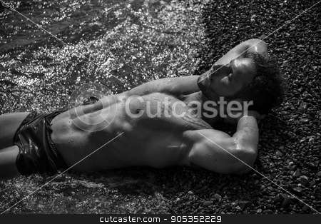 To use this stock image in your creative project, please select the size you need over to the right and click the "Add to Cart" button.
Your downloaded image will come with the Cutcaster watermark removed so don’t worry about the watermark you see on this page. Handsome muscular man on the beach laying on gravel stock photo, Handsome muscular shirtless man on the beach lying on gravel, with eyes closed by Stefano Cavoretto