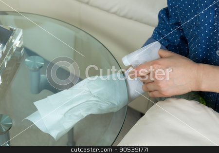 To use this stock image in your creative project, please select the size you need over to the right and click the "Add to Cart" button.
Your downloaded image will come with the Cutcaster watermark removed so don’t worry about the watermark you see on this page. Cleaning underneath Glass End Table stock photo, Horizontal photo female hands wiping underneath glass round end table with spraying cleaning solution bottle and paper towels in hand with sofa and partial lamp in background by tab62