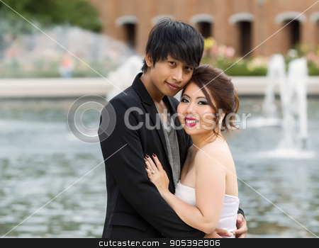 To use this stock image in your creative project, please select the size you need over to the right and click the "Add to Cart" button.
Your downloaded image will come with the Cutcaster watermark removed so don’t worry about the watermark you see on this page. Young Adult Couple Closely Holding Each Other stock photo, Closeup horizontal photo of young adult couple, looking forward, while holding each other with water fountain, flowers, trees and brick building in background by tab62