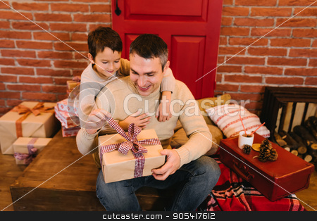To use this stock image in your creative project, please select the size you need over to the right and click the "Add to Cart" button.
Your downloaded image will come with the Cutcaster watermark removed so don’t worry about the watermark you see on this page. The father gives his son a gift for Christmas stock photo, Young parents give his son a Christmas present by Igor Kopakov