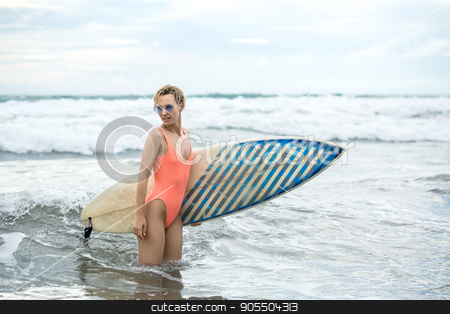 To use this stock image in your creative project, please select the size you need over to the right and click the "Add to Cart" button.
Your downloaded image will come with the Cutcaster watermark removed so don’t worry about the watermark you see on this page. Blonde with surfboard on beach stock photo, Delightful blonde girl with short hairstyle stands sideways in the water on the beach on the background of the sea and the cloudy sky. She wears orange swimsuit with sunglasses and holds a surfboard by bezikus