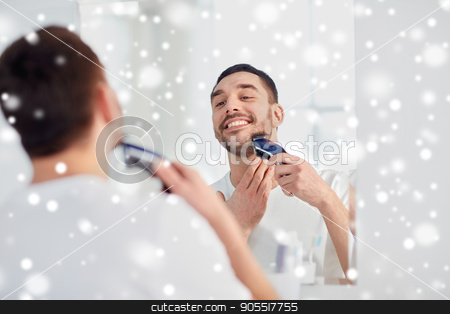 To use this stock image in your creative project, please select the size you need over to the right and click the "Add to Cart" button.
Your downloaded image will come with the Cutcaster watermark removed so don’t worry about the watermark you see on this page. man shaving beard with trimmer at bathroom stock photo, beauty, grooming, winter, christmas and people concept - young man looking to mirror and shaving beard with trimmer or electric shaver at home bathroom over snow by Syda Productions