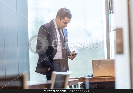 To use this stock image in your creative project, please select the size you need over to the right and click the "Add to Cart" button.
Your downloaded image will come with the Cutcaster watermark removed so don’t worry about the watermark you see on this page. Businessman looking at smart phone in modern corporate office. stock photo, Trough the window view of businessman looking at smart phone in modern corporate office. by kasto