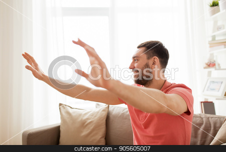 To use this stock image in your creative project, please select the size you need over to the right and click the "Add to Cart" button.
Your downloaded image will come with the Cutcaster watermark removed so don’t worry about the watermark you see on this page. happy man touching something imaginary at home stock photo, virtual reality, entertainment and people concept - happy man touching something imaginary at home by Syda Productions