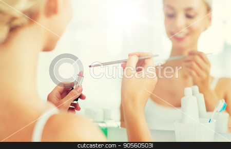 To use this stock image in your creative project, please select the size you need over to the right and click the "Add to Cart" button.
Your downloaded image will come with the Cutcaster watermark removed so don’t worry about the watermark you see on this page. woman with lipstick and make up brush at bathroom stock photo, beauty, make up, cosmetics, morning and people concept - close up of smiling young woman with lipstick and make up brush at home bathroom mirror by Syda Productions
