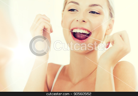 To use this stock image in your creative project, please select the size you need over to the right and click the "Add to Cart" button.
Your downloaded image will come with the Cutcaster watermark removed so don’t worry about the watermark you see on this page. woman with dental floss cleaning teeth at bathroom stock photo, health care, dental hygiene, people and beauty concept - smiling young woman with floss cleaning teeth and looking to mirror at home bathroom by Syda Productions
