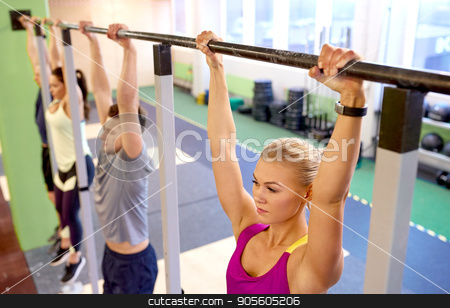 To use this stock image in your creative project, please select the size you need over to the right and click the "Add to Cart" button.
Your downloaded image will come with the Cutcaster watermark removed so don’t worry about the watermark you see on this page. group of people hanging at horizontal bar in gym stock photo, sport, fitness, exercising and people concept - woman with heart-rate tracker hanging on horizontal bar at group training in gym by Syda Productions