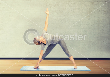 To use this stock image in your creative project, please select the size you need over to the right and click the "Add to Cart" button.
Your downloaded image will come with the Cutcaster watermark removed so don’t worry about the watermark you see on this page. woman making yoga triangle pose on mat stock photo, fitness, sport, people and healthy lifestyle concept - woman making yoga triangle pose on mat over gym room background by Syda Productions
