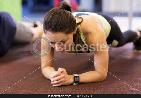 To use this stock image in your creative project, please select the size you need over to the right and click the "Add to Cart" button.
Your downloaded image will come with the Cutcaster watermark removed so don’t worry about the watermark you see on this page. woman with heart-rate tracker exercising in gym stock photo, fitness, sport, exercising and people concept - woman with heart-rate tracker at group training doing plank exercise in gym by Syda Productions