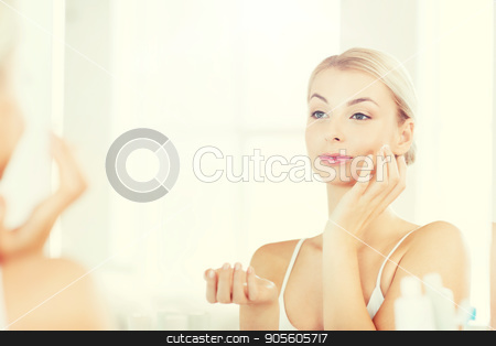 To use this stock image in your creative project, please select the size you need over to the right and click the "Add to Cart" button.
Your downloaded image will come with the Cutcaster watermark removed so don’t worry about the watermark you see on this page. happy woman applying cream to face at bathroom stock photo, beauty, skin care and people concept - smiling young woman applying cream to face and looking to mirror at home bathroom by Syda Productions
