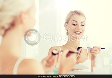 To use this stock image in your creative project, please select the size you need over to the right and click the "Add to Cart" button.
Your downloaded image will come with the Cutcaster watermark removed so don’t worry about the watermark you see on this page. woman with makeup brush and eyeshade at bathroom stock photo, beauty, make up, cosmetics, morning and people concept - young woman applying eyeshade with makeup brush and looking to mirror at home bathroom by Syda Productions