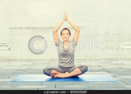 To use this stock image in your creative project, please select the size you need over to the right and click the "Add to Cart" button.
Your downloaded image will come with the Cutcaster watermark removed so don’t worry about the watermark you see on this page. woman making yoga meditation in lotus pose on mat stock photo, fitness, sport, people and healthy lifestyle concept - woman making yoga meditation in lotus pose on mat over urban street background by Syda Productions