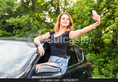 To use this stock image in your creative project, please select the size you need over to the right and click the "Add to Cart" button.
Your downloaded image will come with the Cutcaster watermark removed so don’t worry about the watermark you see on this page. Smiling young woman taking selfie picture with smart phone camera outdoors in car stock photo, Smiling young woman taking selfie picture with smart phone camera outdoors in car by Satura86