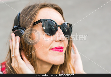To use this stock image in your creative project, please select the size you need over to the right and click the "Add to Cart" button.
Your downloaded image will come with the Cutcaster watermark removed so don’t worry about the watermark you see on this page. Young smiling woman relaxing and listening to music with headphones in the street stock photo, Young smiling woman relaxing and listening to music with headphones in the street by Satura86