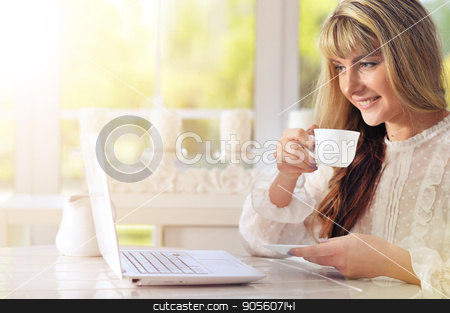 To use this stock image in your creative project, please select the size you need over to the right and click the "Add to Cart" button.
Your downloaded image will come with the Cutcaster watermark removed so don’t worry about the watermark you see on this page. Young woman using laptop stock photo, Young woman sitting at table and using laptop while drinking tea by Ruslan Huzau