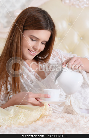To use this stock image in your creative project, please select the size you need over to the right and click the "Add to Cart" button.
Your downloaded image will come with the Cutcaster watermark removed so don’t worry about the watermark you see on this page. Young woman lying on bed stock photo, Beautiful young woman lying on soft beige bed and drinking tea by Ruslan Huzau