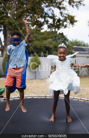 To use this stock image in your creative project, please select the size you need over to the right and click the "Add to Cart" button.
Your downloaded image will come with the Cutcaster watermark removed so don’t worry about the watermark you see on this page. Playful siblings in costumes jumping on trampoline stock photo, Playful siblings in costumes jumping on trampoline at lawn by Wavebreak Media