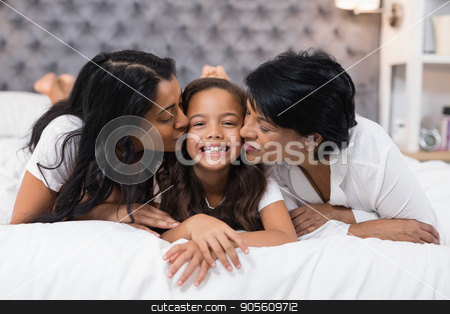 To use this stock image in your creative project, please select the size you need over to the right and click the "Add to Cart" button.
Your downloaded image will come with the Cutcaster watermark removed so don’t worry about the watermark you see on this page. Grandmother and mother kissing smiling girl while lying on bed stock photo, Grandmother and mother kissing smiling girl while lying on bed at home by Wavebreak Media