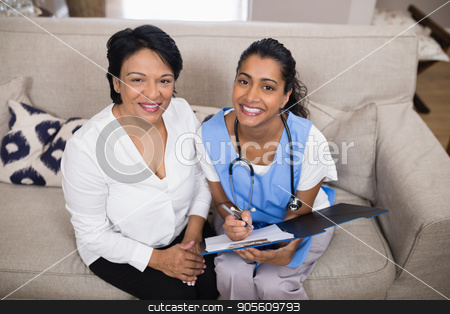 To use this stock image in your creative project, please select the size you need over to the right and click the "Add to Cart" button.
Your downloaded image will come with the Cutcaster watermark removed so don’t worry about the watermark you see on this page. Portrait of smiling patient sitting with doctor checking medical report stock photo, Portrait of smiling patient sitting with doctor checking medical report on sofa at home by Wavebreak Media