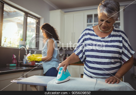 To use this stock image in your creative project, please select the size you need over to the right and click the "Add to Cart" button.
Your downloaded image will come with the Cutcaster watermark removed so don’t worry about the watermark you see on this page. Mother ironing clothes while daughter washing utensil stock photo, Mother ironing clothes while daughter washing utensil at home by Wavebreak Media