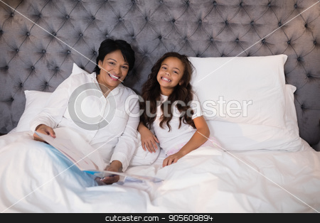To use this stock image in your creative project, please select the size you need over to the right and click the "Add to Cart" button.
Your downloaded image will come with the Cutcaster watermark removed so don’t worry about the watermark you see on this page. Cheerful grandmother and granddaughter resting on bed at home stock photo, Portrait of cheerful grandmother and granddaughter resting on bed at home by Wavebreak Media