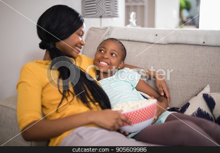 To use this stock image in your creative project, please select the size you need over to the right and click the "Add to Cart" button.
Your downloaded image will come with the Cutcaster watermark removed so don’t worry about the watermark you see on this page. Mother and daughter having popcorn while resting on sofa at home stock photo, Smiling mother and daughter having popcorn while resting on sofa at home by Wavebreak Media