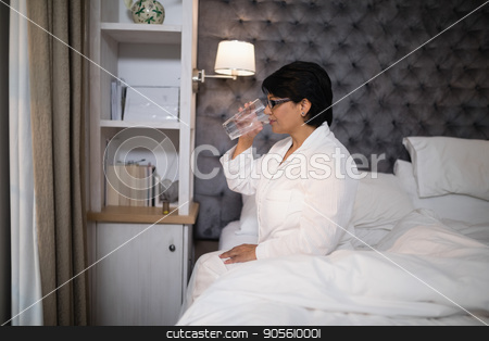To use this stock image in your creative project, please select the size you need over to the right and click the "Add to Cart" button.
Your downloaded image will come with the Cutcaster watermark removed so don’t worry about the watermark you see on this page. Mature woman drinking water while sitting on bed stock photo, Mature woman drinking water while sitting on bed at home by Wavebreak Media