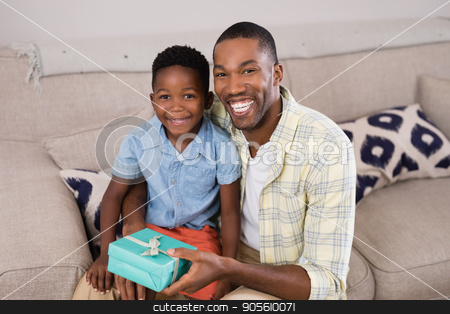 To use this stock image in your creative project, please select the size you need over to the right and click the "Add to Cart" button.
Your downloaded image will come with the Cutcaster watermark removed so don’t worry about the watermark you see on this page. Smiling father and son with gift box sitting on sofa at home stock photo, Portrait of smiling father and son with gift box sitting on sofa at home by Wavebreak Media