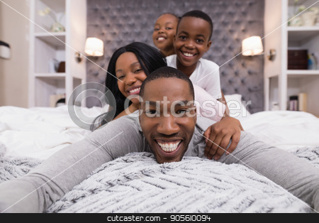 To use this stock image in your creative project, please select the size you need over to the right and click the "Add to Cart" button.
Your downloaded image will come with the Cutcaster watermark removed so don’t worry about the watermark you see on this page. Portrait of happy man lying with family on bed stock photo, Portrait of happy man lying with family on bed at home by Wavebreak Media