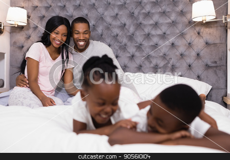 To use this stock image in your creative project, please select the size you need over to the right and click the "Add to Cart" button.
Your downloaded image will come with the Cutcaster watermark removed so don’t worry about the watermark you see on this page. Happy couple sitting with children lying in foreground stock photo, Happy couple sitting on bed with children lying in foreground at home by Wavebreak Media