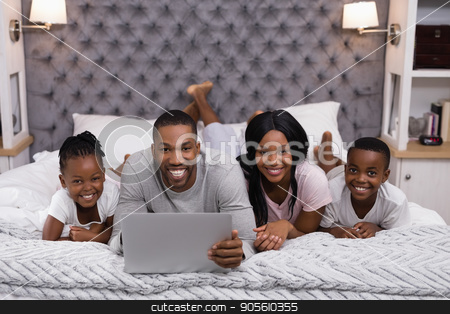 To use this stock image in your creative project, please select the size you need over to the right and click the "Add to Cart" button.
Your downloaded image will come with the Cutcaster watermark removed so don’t worry about the watermark you see on this page. Portrait of smiling family using laptop while lying together on bed stock photo, Portrait of smiling family using laptop while lying together on bed at home by Wavebreak Media