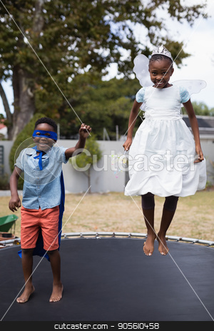 To use this stock image in your creative project, please select the size you need over to the right and click the "Add to Cart" button.
Your downloaded image will come with the Cutcaster watermark removed so don’t worry about the watermark you see on this page. Siblings in costumes jumping on trampoline at lawn stock photo, Full length of siblings in costumes jumping on trampoline at lawn by Wavebreak Media