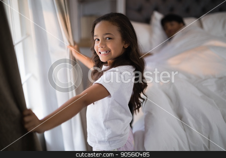 To use this stock image in your creative project, please select the size you need over to the right and click the "Add to Cart" button.
Your downloaded image will come with the Cutcaster watermark removed so don’t worry about the watermark you see on this page. Portrait of of happy girl holding curtains in bedroom stock photo, Portrait of of happy girl holding curtains in bedroom at home by Wavebreak Media